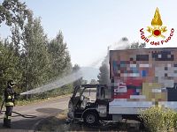 Il furgone incendiato e i vigili del fuoco al lavoro