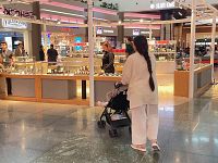 Una mamma col figlio in passeggino nell'aeroporto di Istanbul