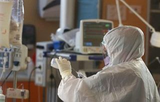 infermieri in tenuta anti Covid a un macchinario di terapia intensiva