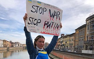Donna con in mano un cartello con la scritta "Stop War Stop Putin"