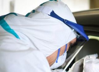infermiere in tenuta anti covid in un drive through