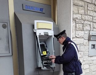 Un carabiniere davanti a uno sportello bancomat