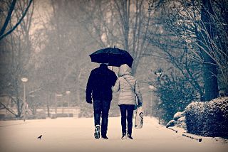 persone sotto la neve con l'ombrello