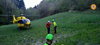 Elicottero Pegaso1 atterrato in un prato e personale del Soccorso Alpino