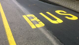scritta gialla bus sull'asfalto