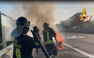 incendio in autostrada e vigili del fuoco in azione
