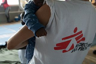 operatore medici senza frontiere con bimbo in braccio