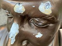 Il particolare del volto della statua sfregiato