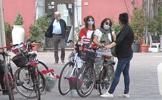 persone con la mascherina in bicicletta