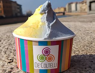 coppetta di gelato due gusti, giallo e blu, sulle spallette del lungarno di Pisa