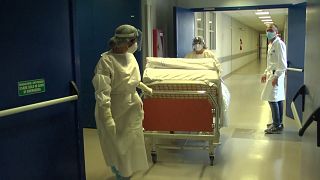 infermieri trasportano un letto nel corridoio di un ospedale