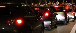 auto in fila al casello autostradale di notte