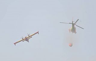 Un canadair e un elicottero antincendio in azione