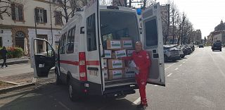 volontario croce rossa carica i farmaci sul mezzo di trasporto