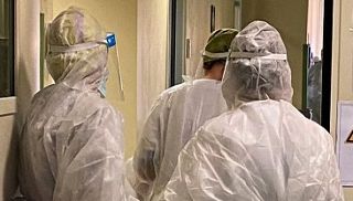 medici in tenuta anti covid nel corridoio di un ospedale