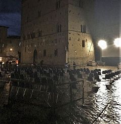 Piazza dei Priori bagnata dalla pioggia e le sedie vuote