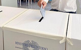 Un elettore infila la scheda nell'urna