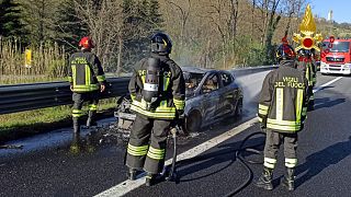 I vigili del fuoco e l'auto distrutta dall'incendio