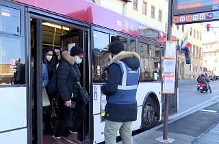 Persone con la mascherina scendono da un autobus
