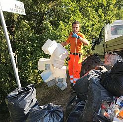 un operatore ecologico rimuove rifiuti per strada