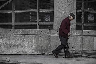 anziano cammina col bastone