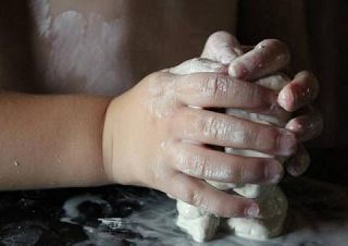 mani di bambino lavorano l'argilla
