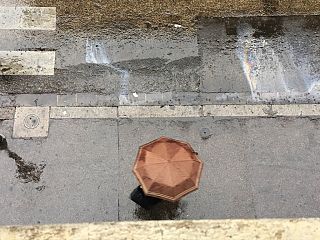 Un passante si ripara con un ombrello