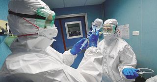 medici in tenuta anti covid con una flebo