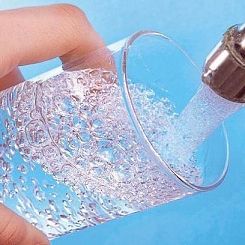 bicchiere sotto a un rubinetto aperto