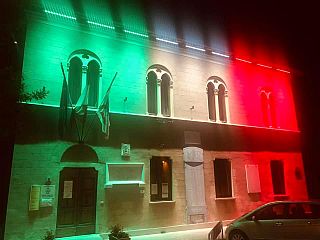 Il vecchio palazzo comunale con illuminazione tricolore