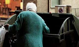 signora a un cassonetto