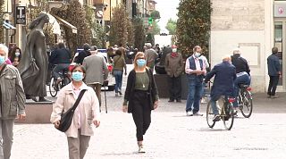 Gente che cammina per strada con la mascherina