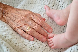mano anziana e piedini di neonato