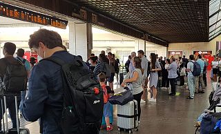 persone che aspettano i treni