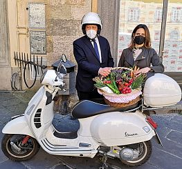 sindaco con cestino di merci e scooter