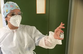 Un'infermiera mostra una fiala di vaccino AstraZeneca