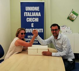 Silvia Chelazzi e Marco Savoli si danno la mano, in mezzo la scatola multimediale