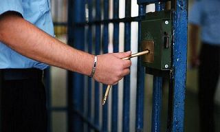 mano di poliziotto penitenziario chiude una cella