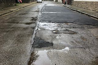 Lo stato della strada con asfalto e buche
