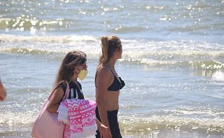 Due ragazze sulla spiaggia, una con la mascherina - foto di repertorio