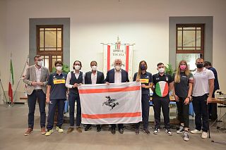Gli atleti in Palazzo Strozzi Sacrati con Giani e la bandiera della Toscana