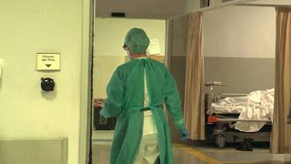 infermiere in tenuta anti Covid nel corridoio di un ospedale di spalle
