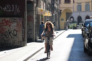 Signora in bicicletta a Firenze con mascherina