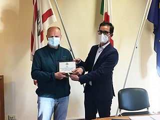 Aldo Mancini mentre riceve la targa dal sindaco Marco Ermini